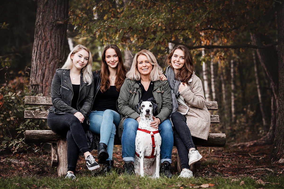 Familienfoto mit Hund auf einer Bank